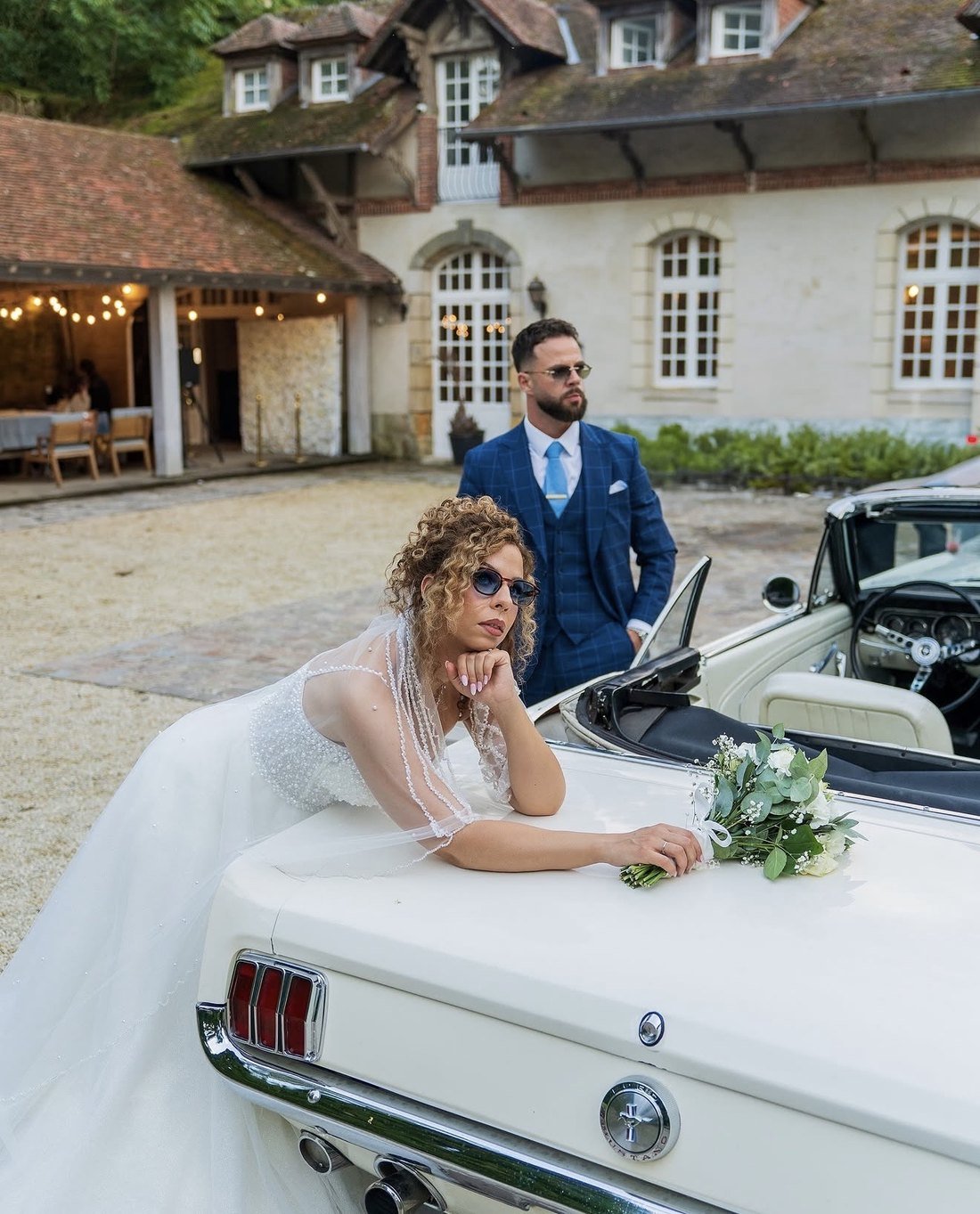 Couple de mariés près d’une voiture ancienne
